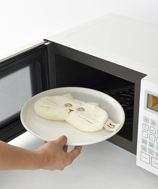 ネコ形のアイピローを電子レンジに入れる様子