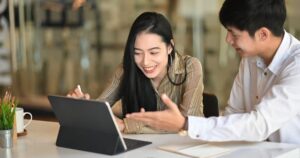 タブレットを見ながら話し合う男女