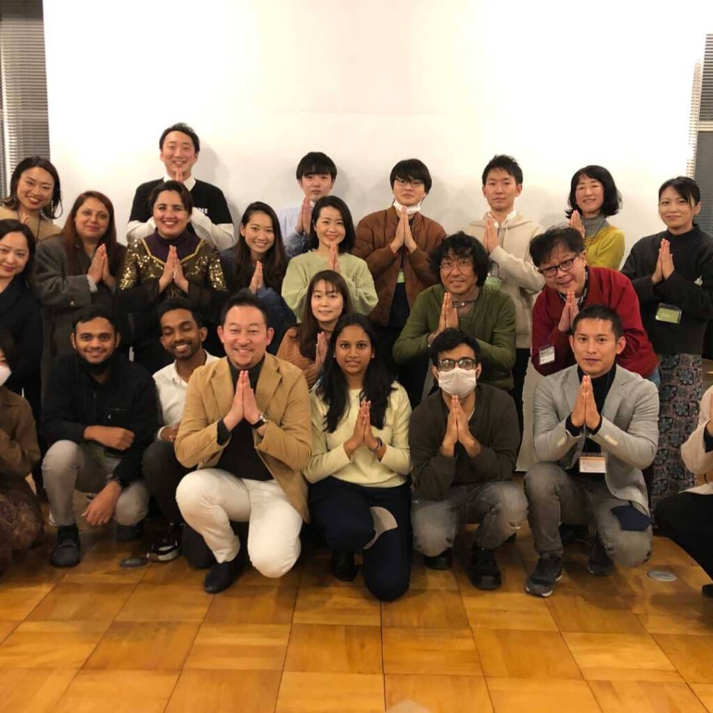 両手を合わせたポーズで並ぶ参加者の集合写真